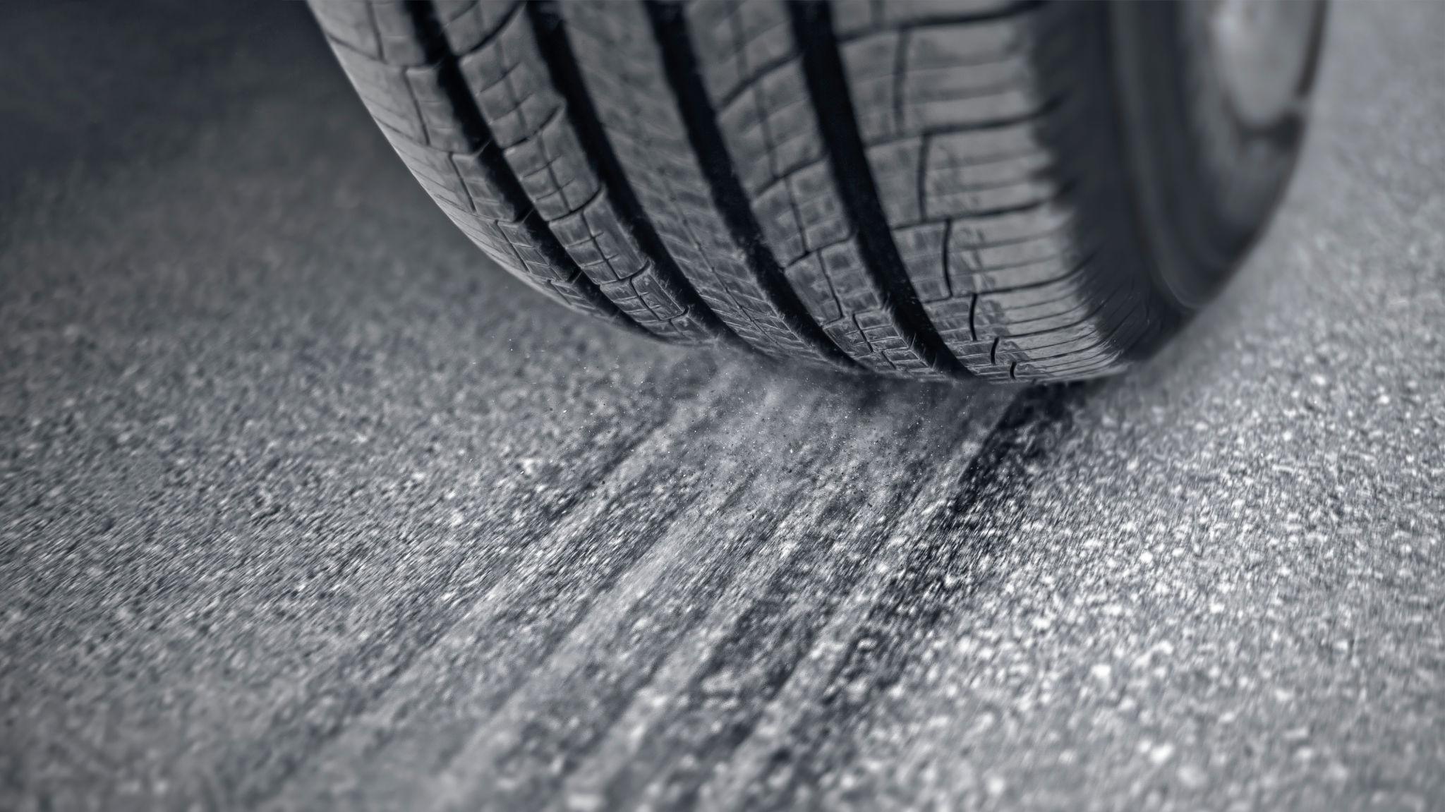 Close-up of a tire where it meets the road, showing the rubber flexing at the contact patch